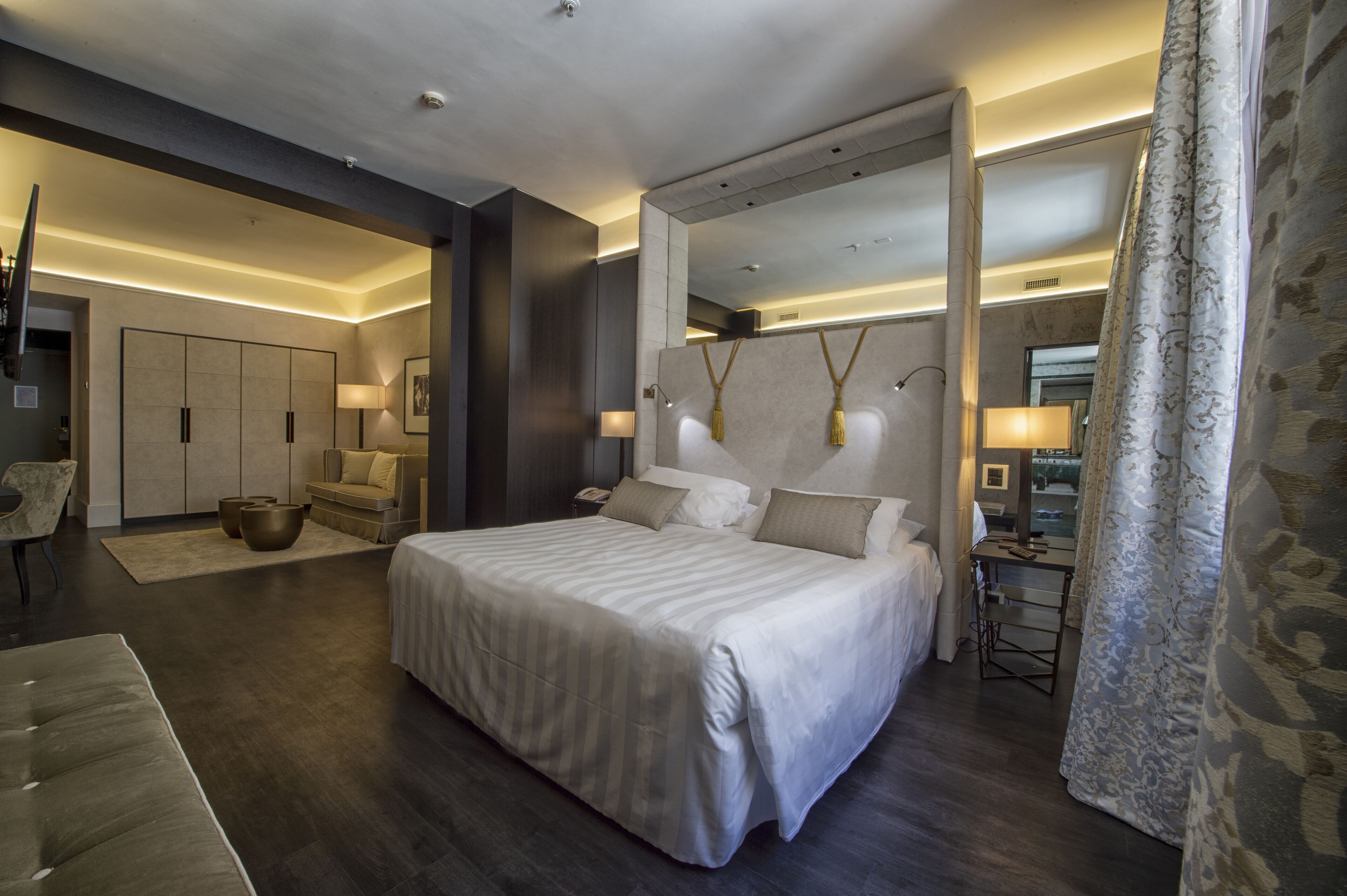 A modern hotel room with a large bed, a desk, and a chair.