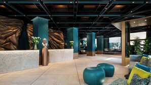A modern lobby with a central seating area, large columns, and a textured wall. - Sina Bernini Bristol, Autograph Collection (Rome)