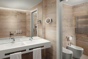 Un bagno moderno con un ampio lavabo, un bidet e uno specchio con luce integrata.