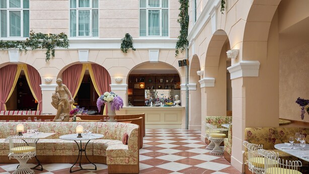 A hotel lobby with checkered flooring, seating areas, and a bar. - Hotel Bella Grande (Copenhagen)