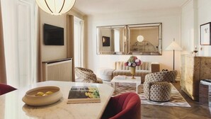 A modern living room with a marble table, red chairs, a sofa, and a large mirror. - Hotel Bella Grande (Copenhagen)