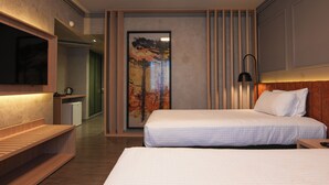 Habitación de hotel moderna con una cama grande, un banco de madera, un televisor de pantalla plana y un cuadro en la pared.