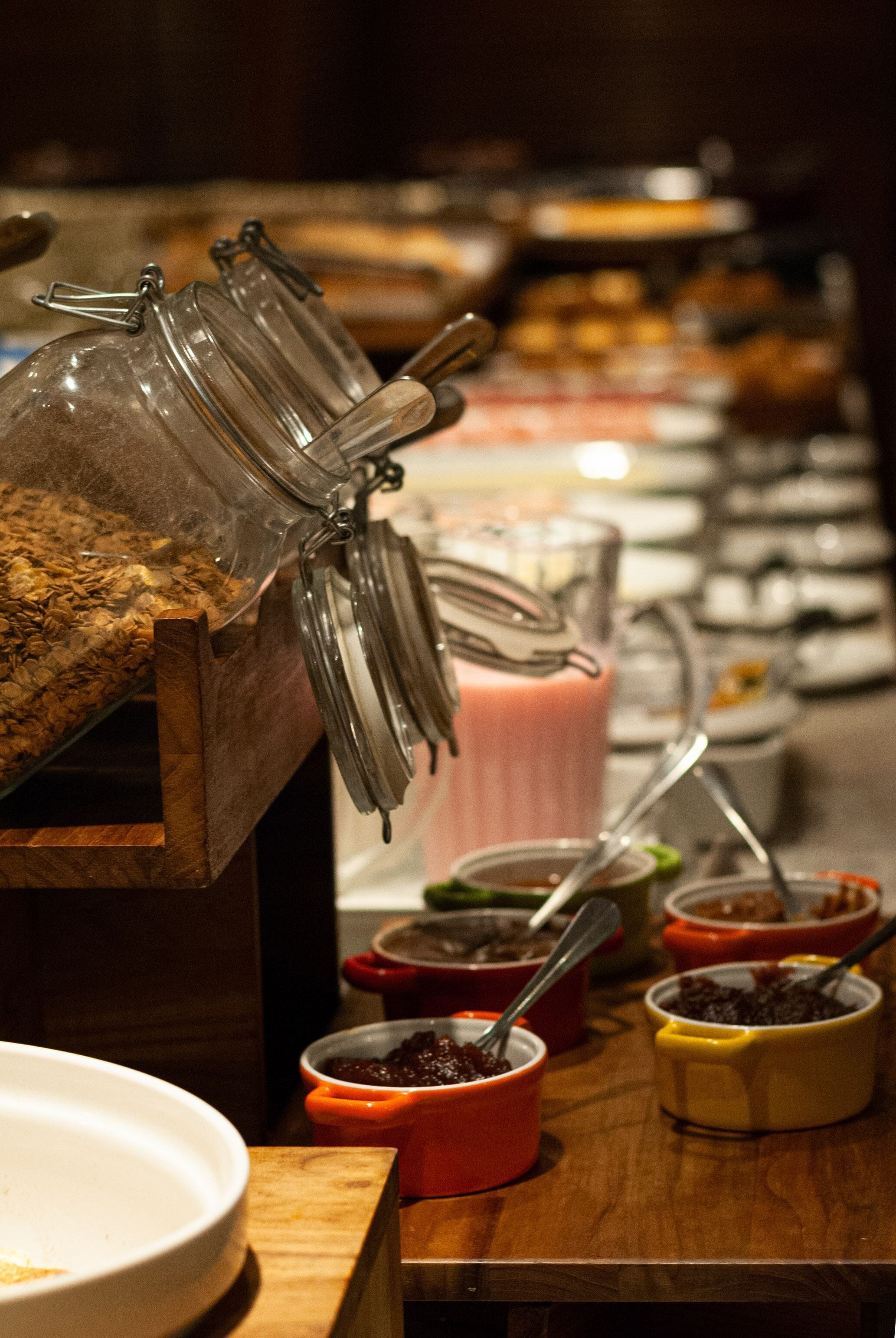 A buffet setup with various food items and containers.
