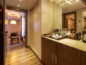 A hotel bathroom with a large mirror, wooden cabinets, and a countertop with toiletries. - Grand Mercure Curitiba Rayon (Curitiba)