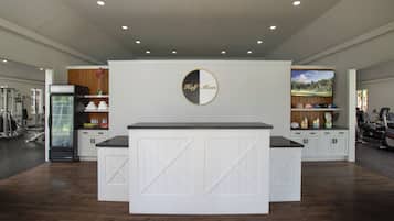 A modern kitchen with a central island, white cabinetry, and a large screen above the island.