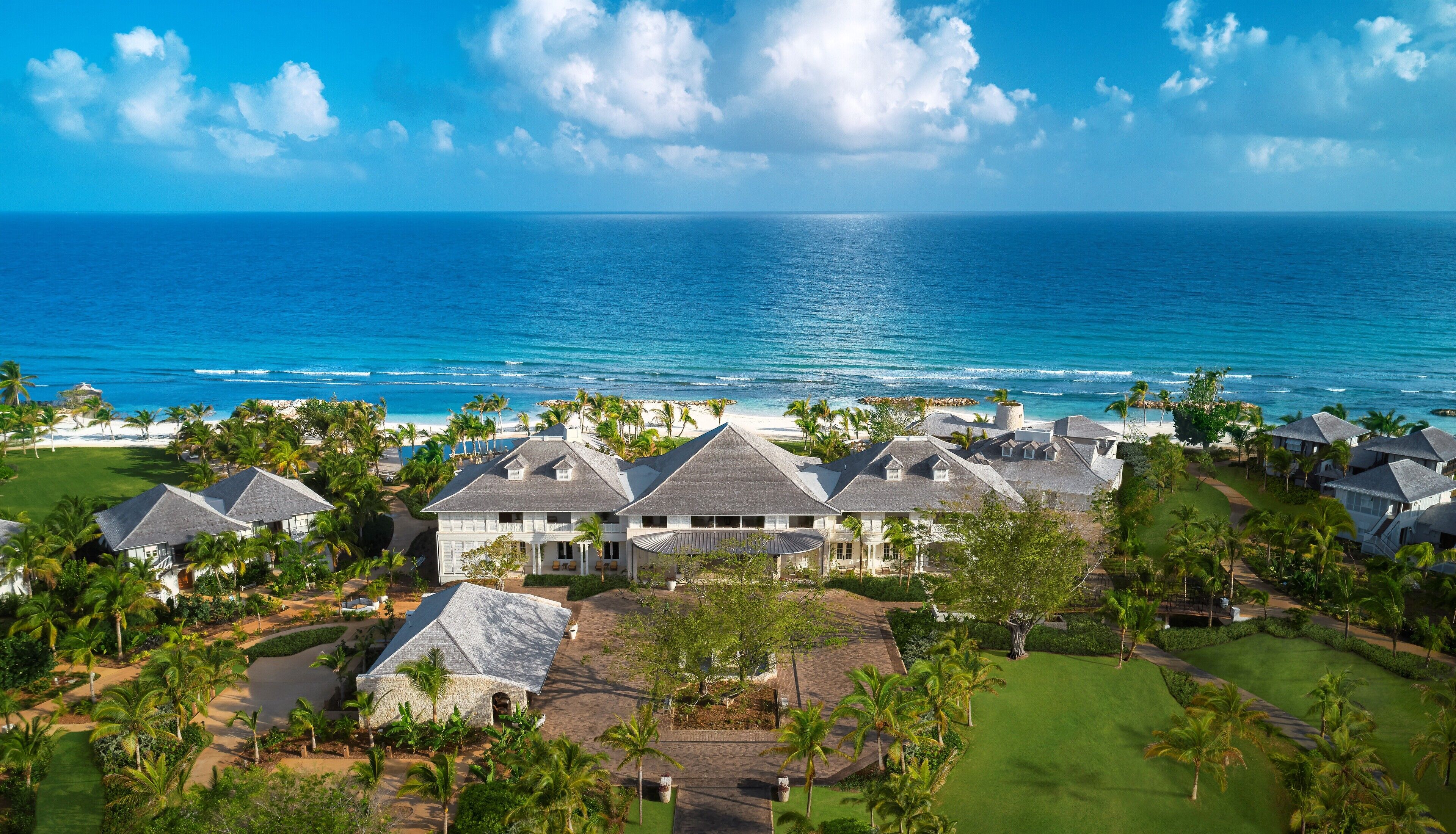 A coastal resort with multiple houses, a beach, and a view of the ocean.