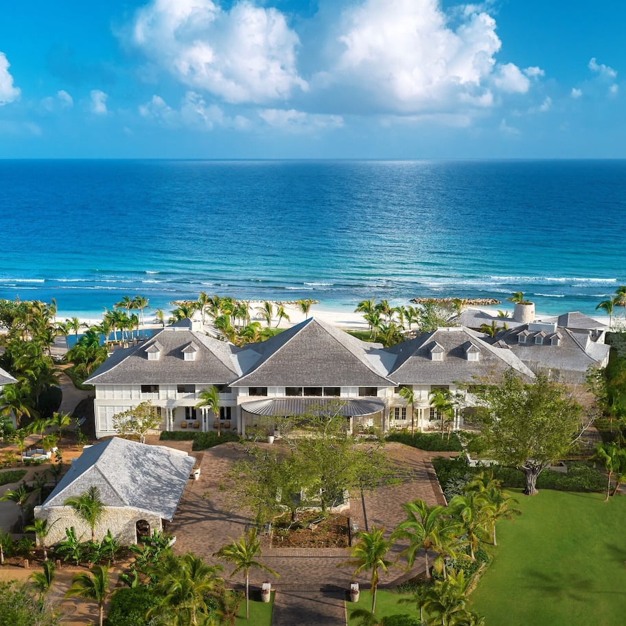 A coastal resort with multiple houses, a beach, and a view of the ocean.