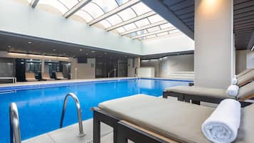 Una piscina cubierta, tumbonas