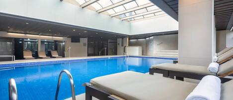 Una piscina cubierta, tumbonas