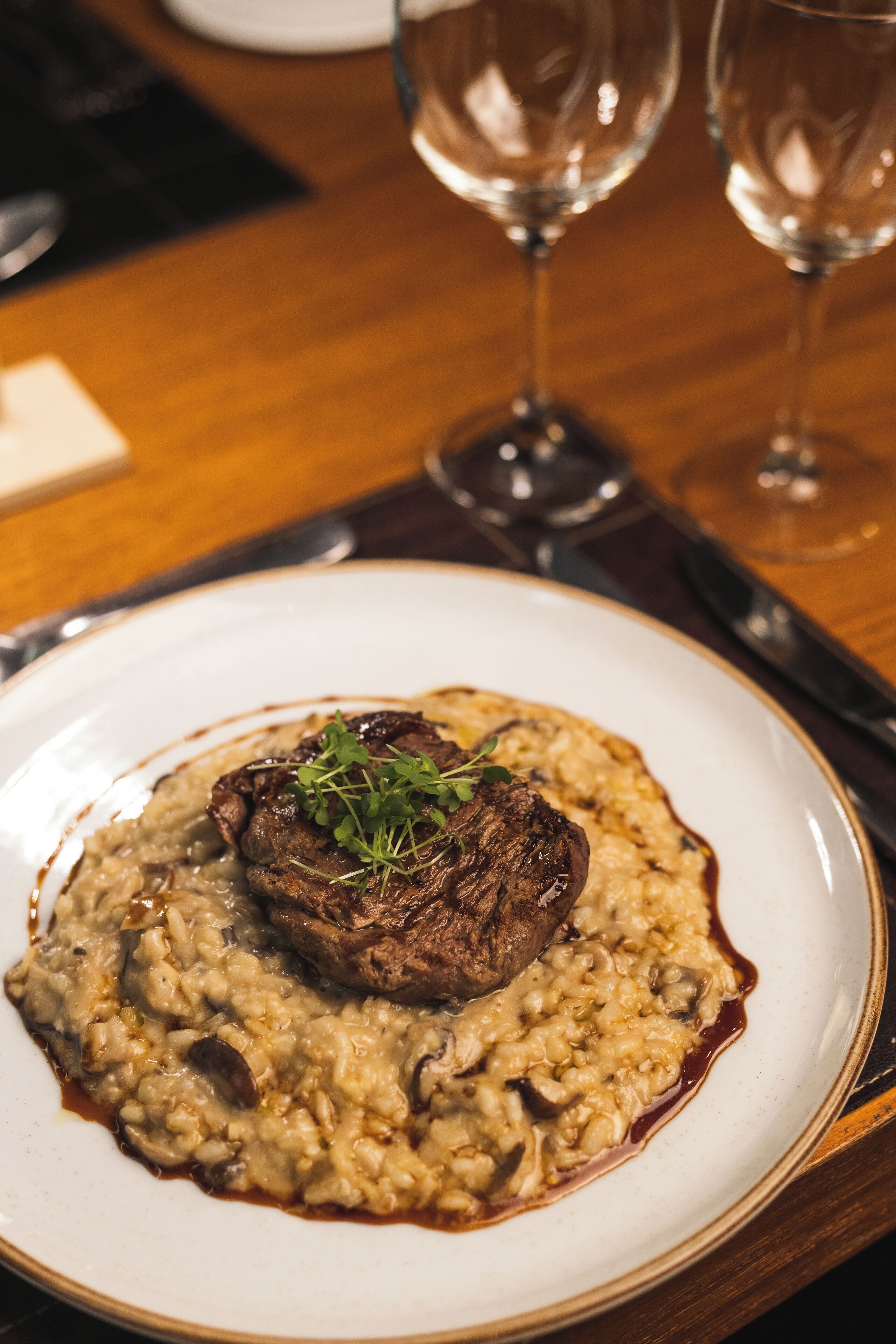 Un plato de comida con carne y risotto.
