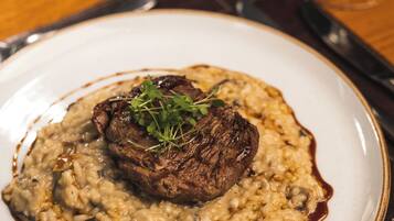 Un plato de comida con carne y risotto.