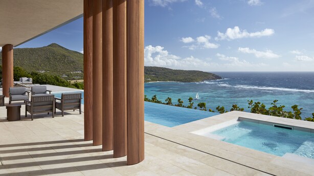 A poolside area with a view of the ocean and a mountainous landscape. - Mandarin Oriental, Canouan (Canouan Island)