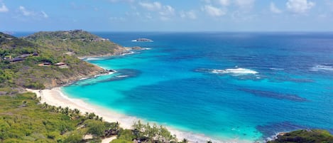 On the beach, white sand, sun loungers, beach umbrellas