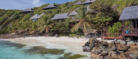 Une propriété située en bord de mer, dotée de bungalows sur pilotis, d’eaux turquoise cristallines et d’une végétation luxuriante.