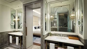 A modern bathroom with two sinks, large mirrors, and a walk-in shower.