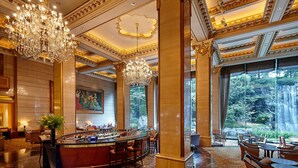 A luxurious lobby with a grand chandelier, a bar area, and large windows offering a view of a waterfall. -  THE GRAND LOTTE SEOUL (Formerly: Lotte Hotel Seoul) (Seoul)