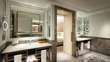 A modern bathroom with a large mirror, dual sinks, and a marble floor.
