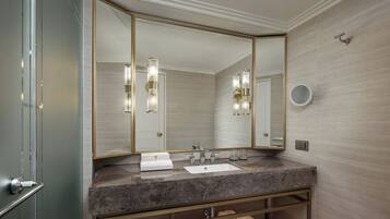 A modern bathroom with a large mirror, two sinks, and a marble countertop.