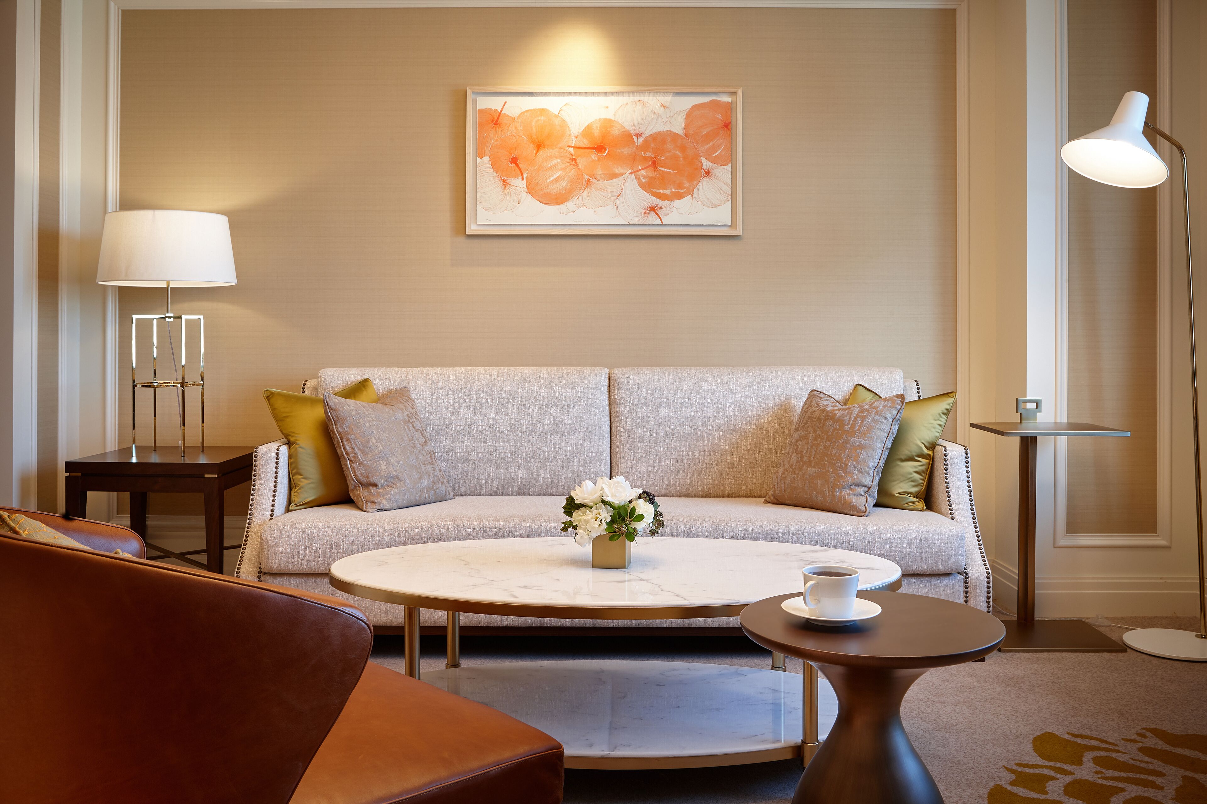 A modern living room with a beige sofa, a round coffee table, and a floor lamp.