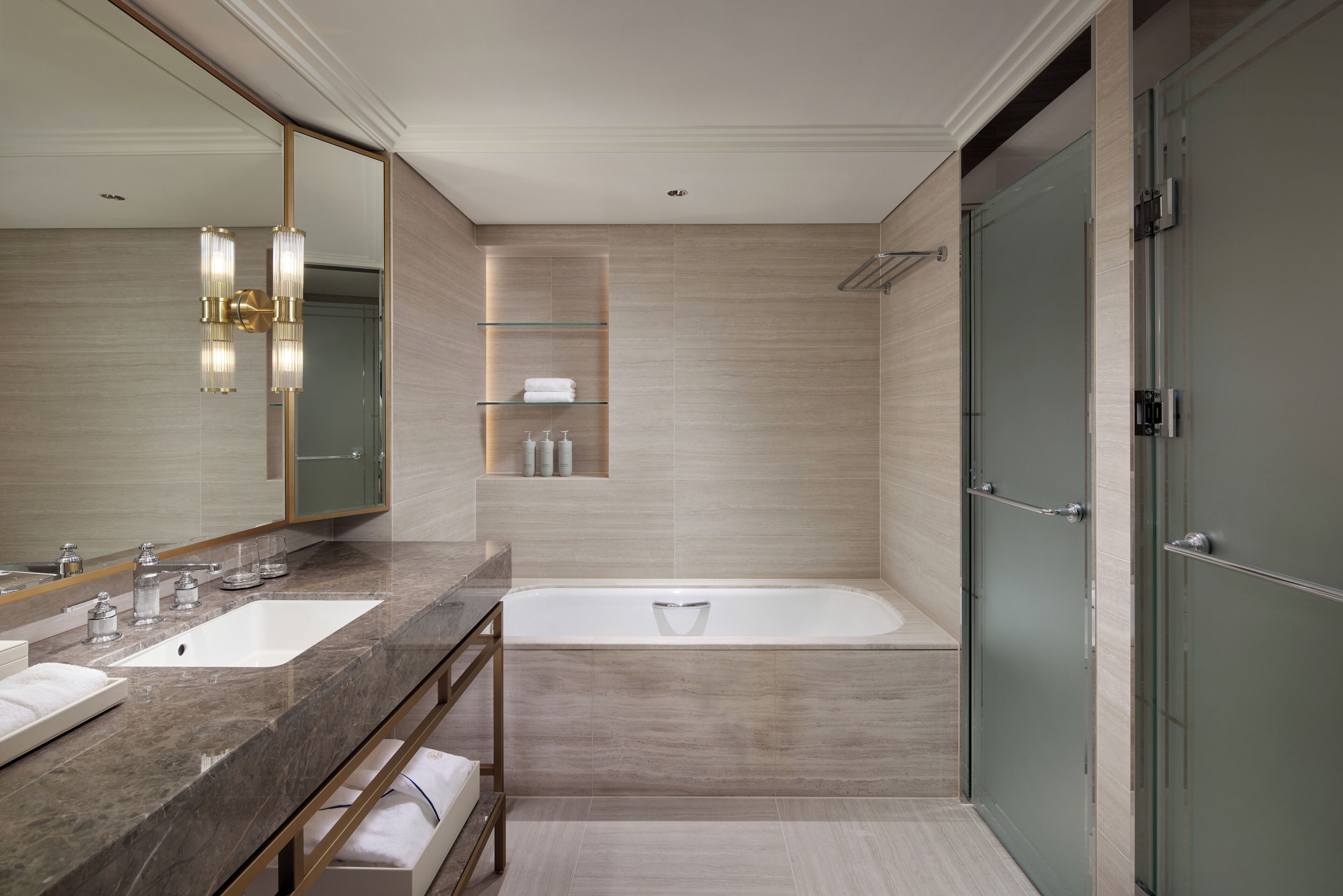 A modern bathroom with two sinks, a bathtub, and a glass shower enclosure.