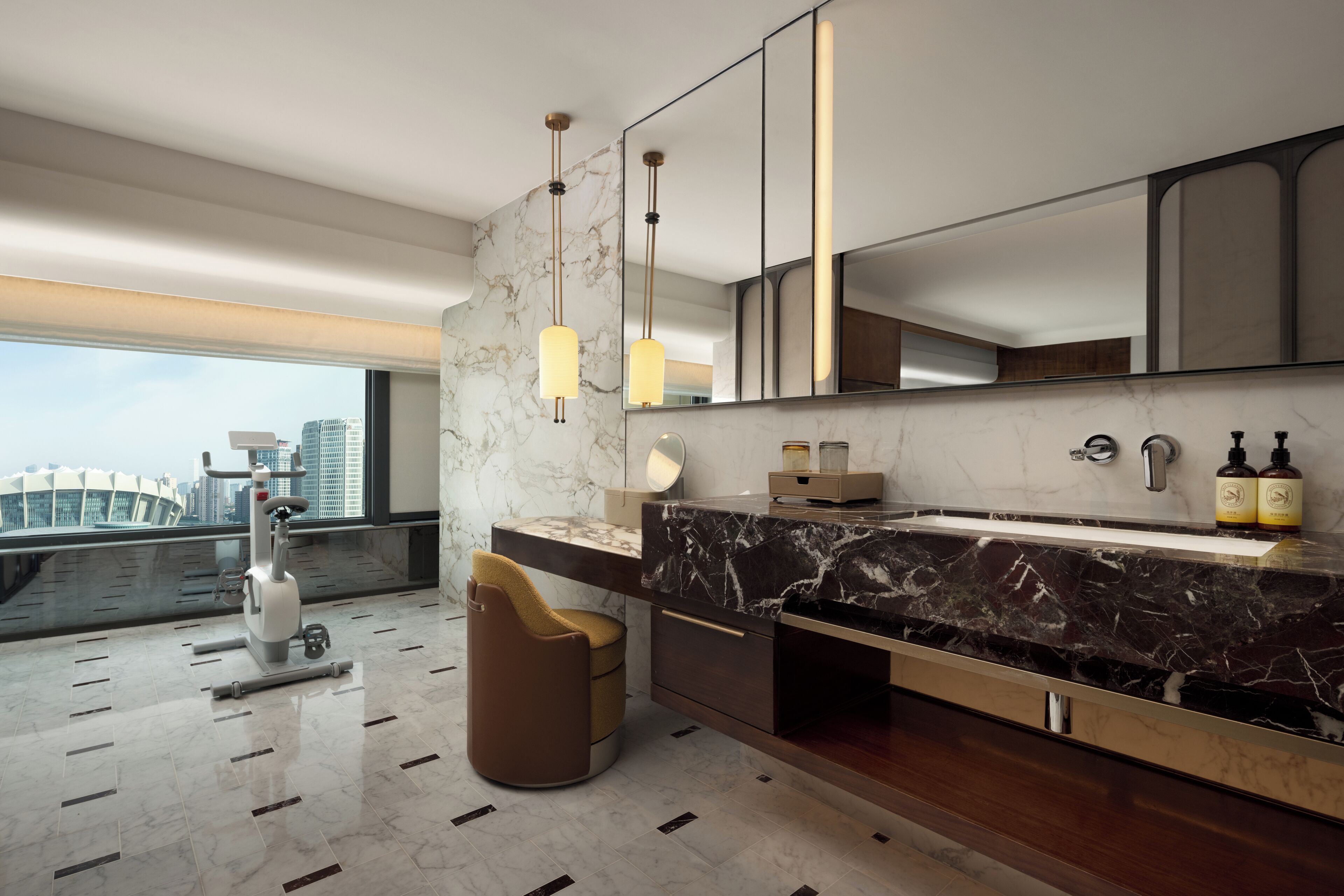 Un baño moderno con un espejo grande, encimera de mármol y vistas a la ciudad.