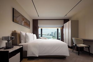 A modern hotel room with a large bed, a desk, a chair, and a city view. - The Kunlun Hua Ting Hotel & Towers,Shanghai (Shanghai)