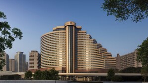 A multi-story hotel with a curved facade, a central vertical feature, and a flat roof. - The Kunlun Hua Ting Hotel & Towers,Shanghai (Shanghai)