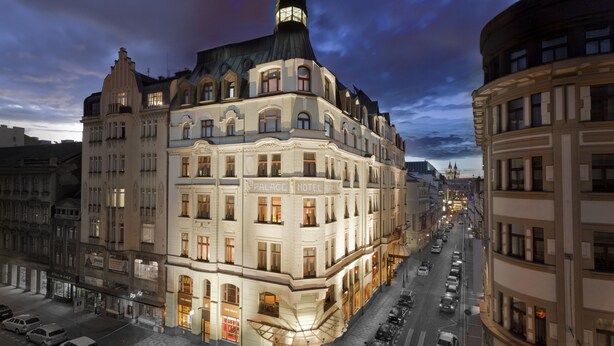 Un hotel histórico con ubicación en esquina, varios pisos y una torre destacada.