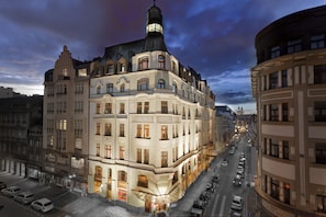 Un hôtel historique situé à un carrefour, doté de plusieurs étages et d’une tour imposante.