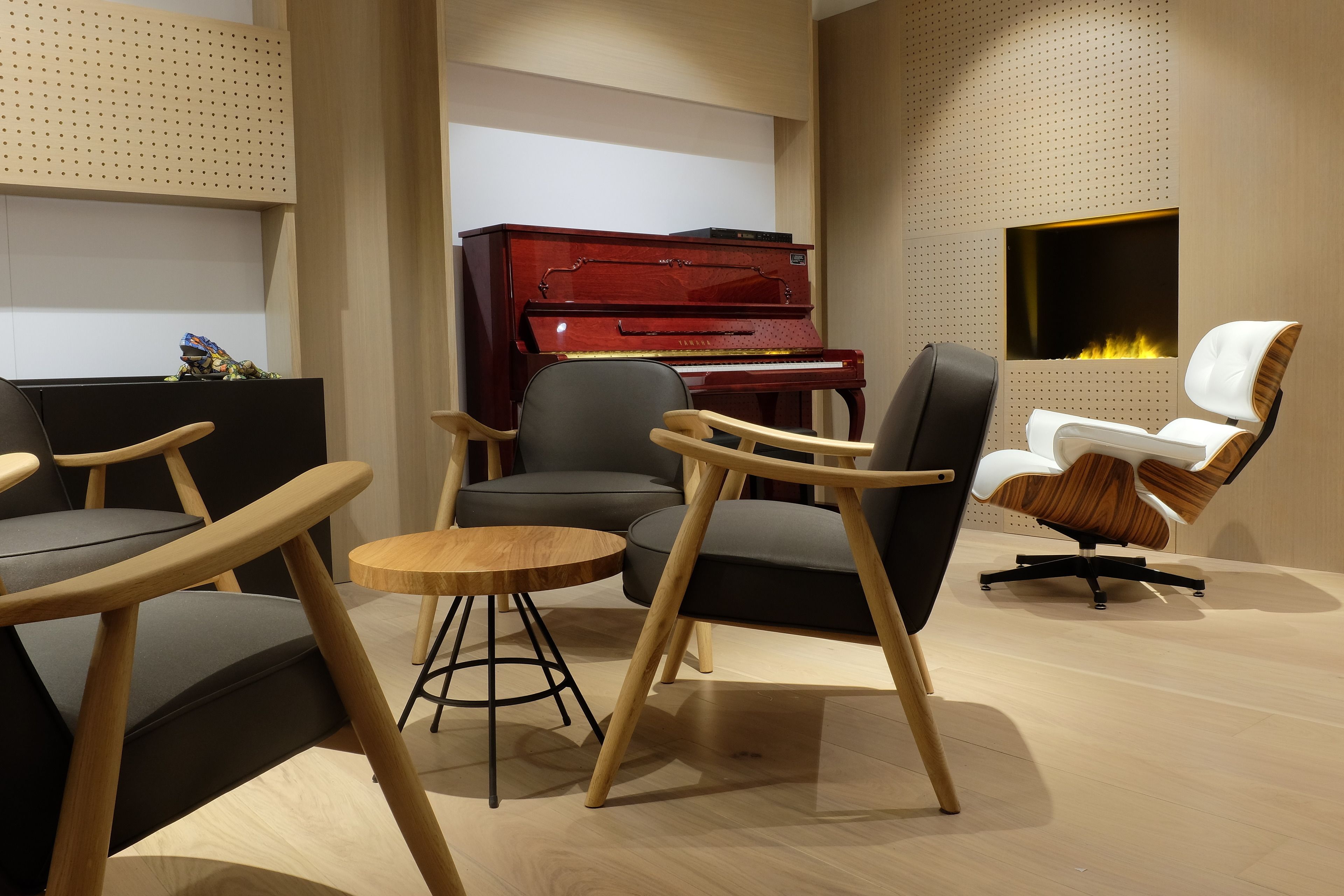 Un salon moderne avec un piano à queue, des sièges confortables et une cheminée.