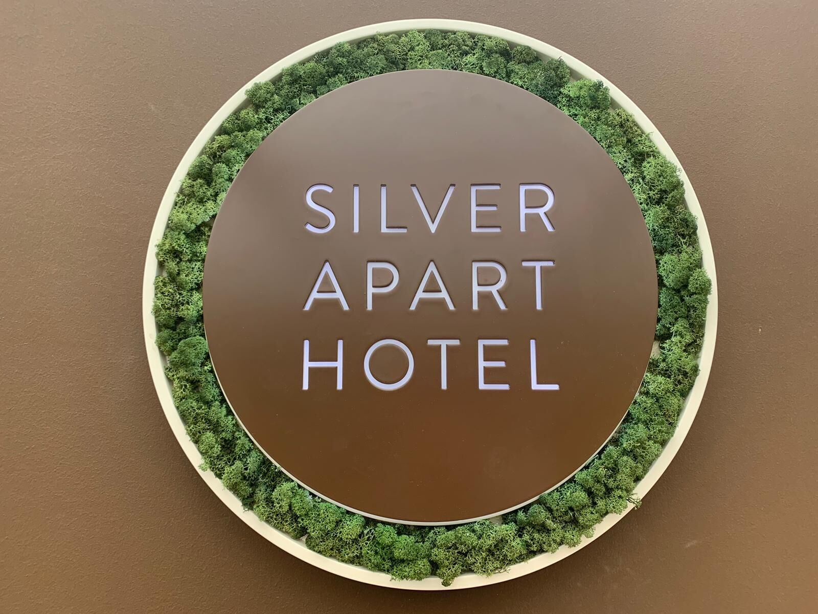Señal circular con el texto "SILVER APART HOTEL" rodeado de un borde verde.