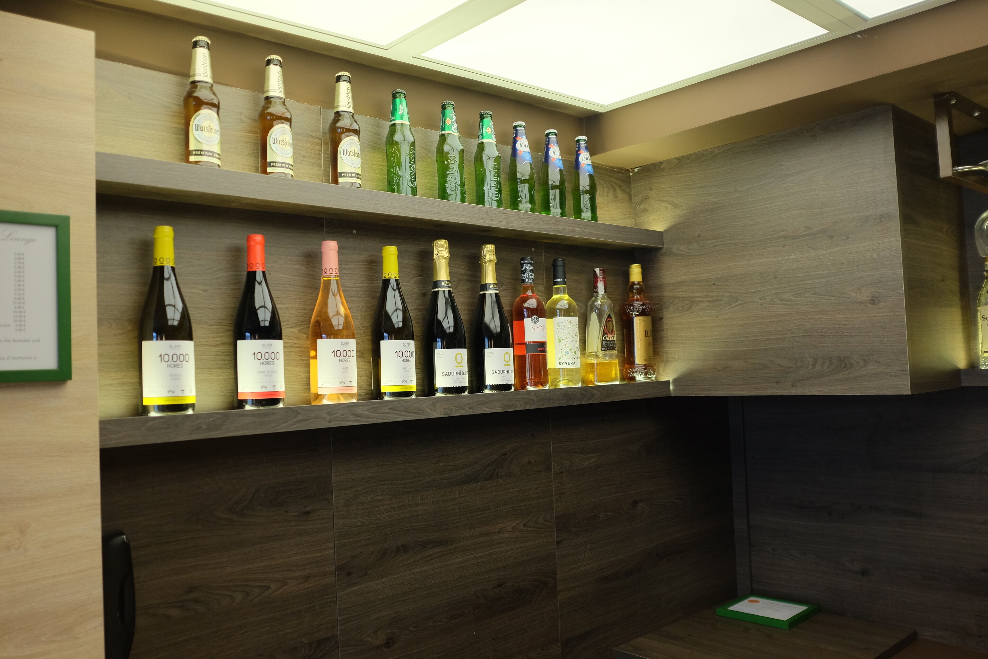 A wine rack with various bottles, including some labeled '10,000' and 'SADURINA'.
