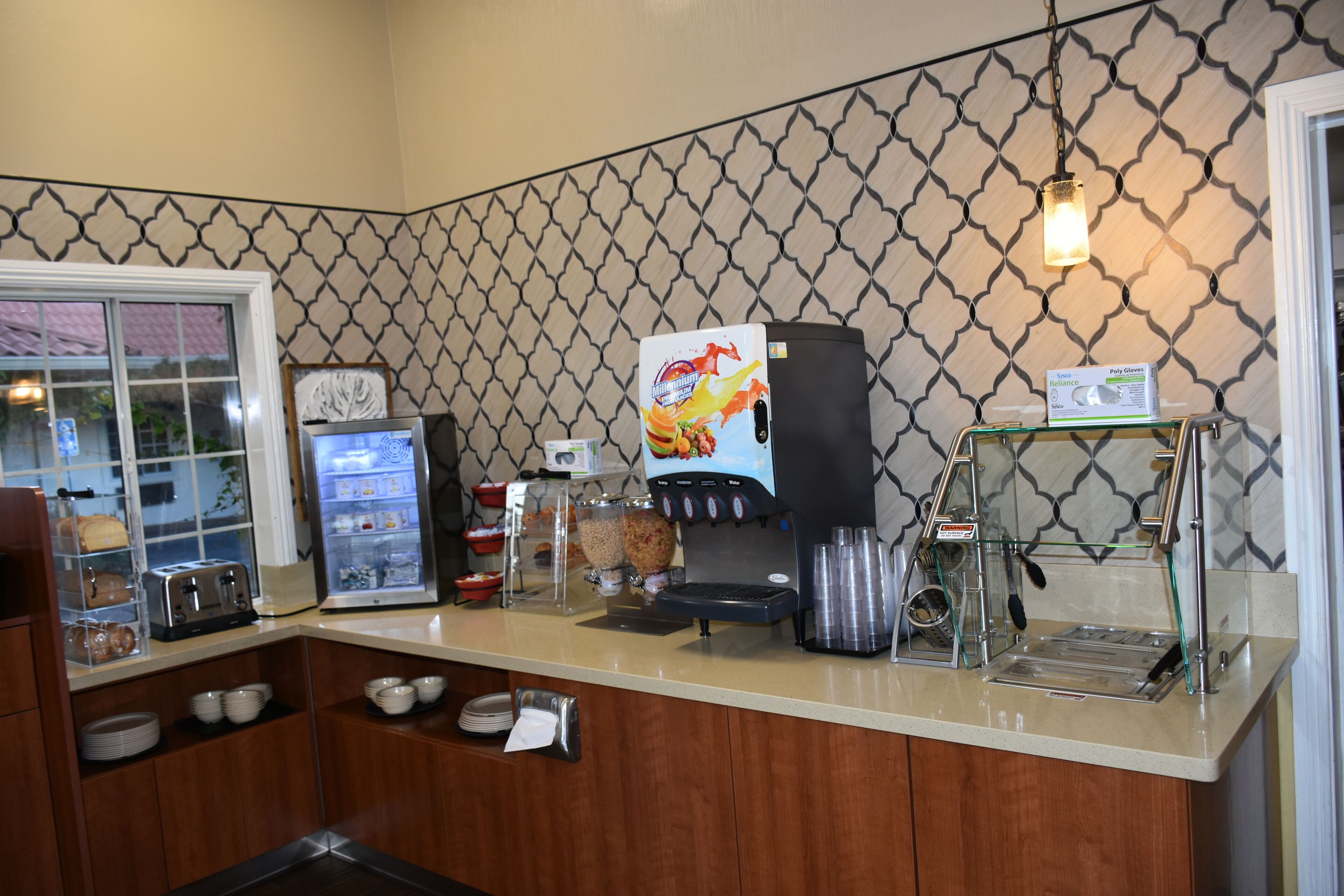 A self-service coffee station with a coffee machine, condiment dispensers, and a water cooler.