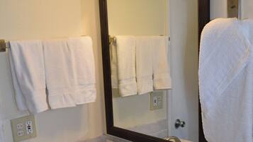 A bathroom with a white sink, two faucets, a mirror, and two wall-mounted lights.
