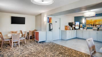 Una habitación de hotel con comedor, kitchenette y un gran ventanal.