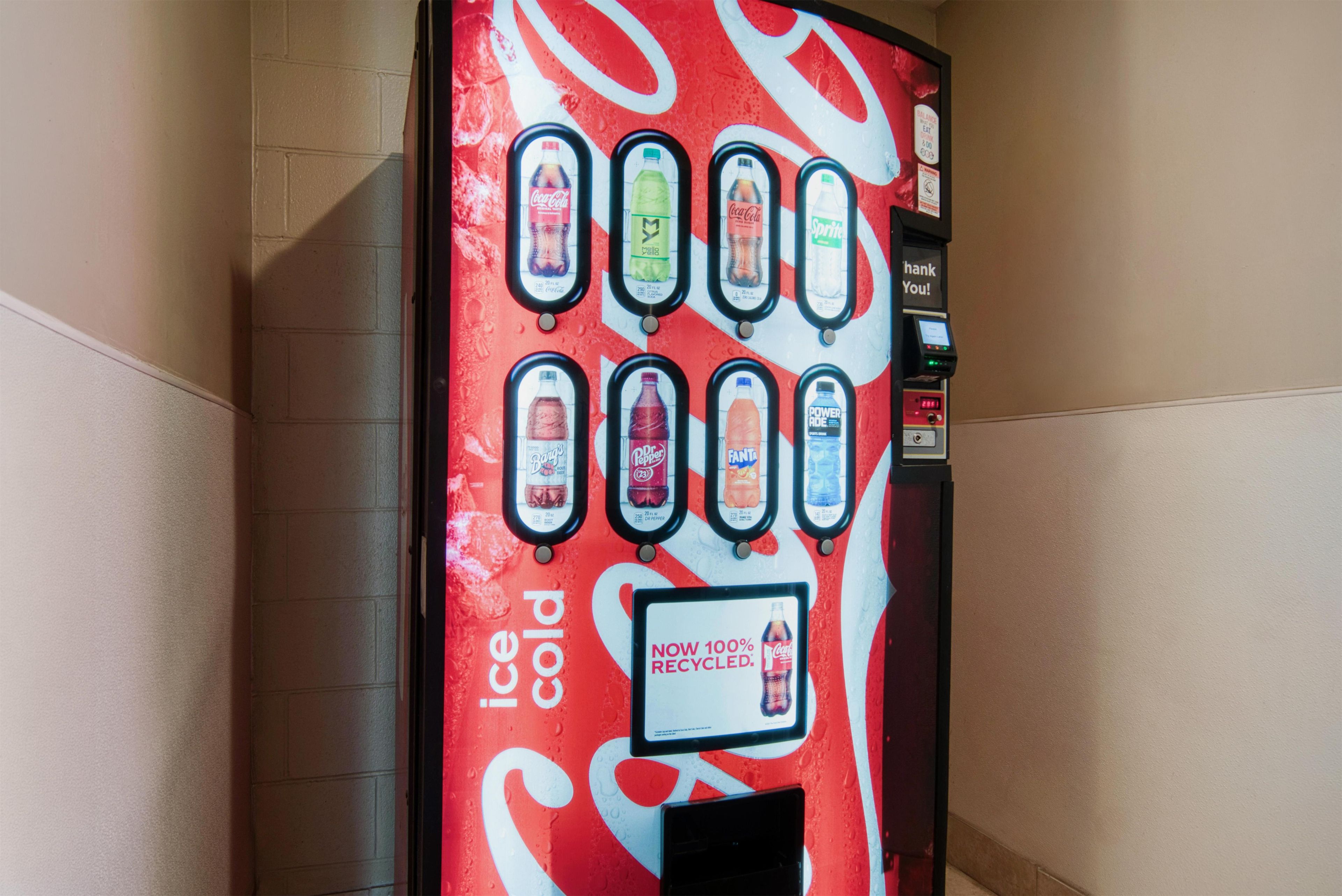 Un distributeur automatique proposant un large choix de boissons, notamment du Coca-Cola, du Sprite et du Fanta.