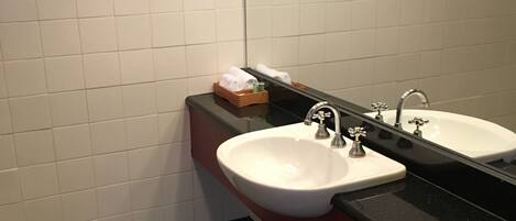 A bathroom with two sinks, a mirror, and a tiled floor.