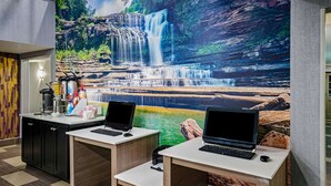 A reception desk with two laptops, a coffee machine, and a beverage dispenser. - La Quinta Inn & Suites by Wyndham Cookeville (Cookeville)
