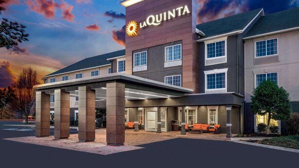 A La Quinta hotel with a modern facade, large entrance, and outdoor seating area. - La Quinta Inn & Suites by Wyndham Cookeville (Cookeville)