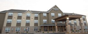 Un hôtel à plusieurs étages, reconnaissable à son enseigne bien visible indiquant « GOURCY INN & SUITES ».