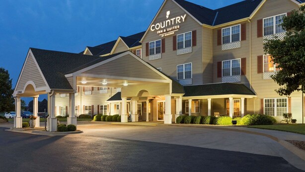 A Country Inn & Suites with a covered entrance, multiple windows, and a well-lit facade. - Country Inn & Suites by Radisson, Salina, KS (Salina)