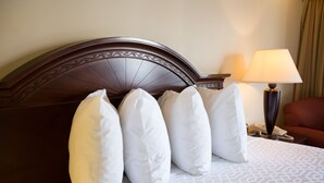 Ein ordentlich gemachtes Bett mit einem gemusterten Überwurf und einem dunklen Holzkopfende.