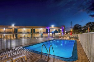 Una piscina al aire libre de temporada, sillones reclinables de piscina