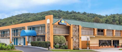 Un hotel Days Inn con techo verde, varios balcones y estacionamiento.