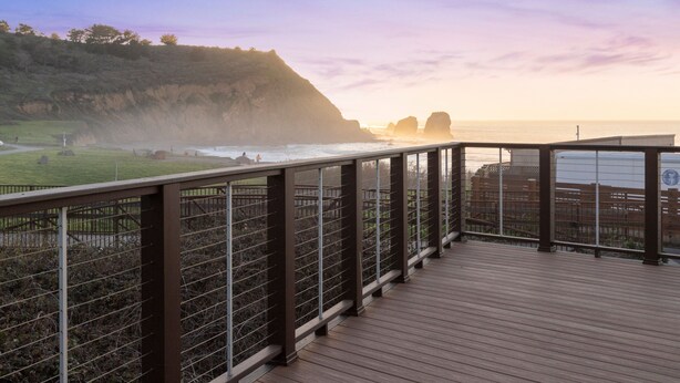 A wooden deck with a metal railing overlooking a coastal landscape with cliffs and the ocean. - Fairfield Inn & Suites by Marriott San Francisco Pacifica (Pacifica)