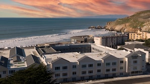 A coastal hotel with multiple buildings, a parking lot, and a view of the ocean and cliffs. - Fairfield Inn & Suites by Marriott San Francisco Pacifica (Pacifica)