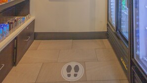 A narrow corridor with a refrigerated display case on the right and shelves stocked with snacks on the left. - Holiday Inn & Suites Spring- The Woodlands Area by IHG (Spring)