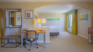 A hotel room with a desk, chair, bed, and a view of the outdoors. - Holiday Inn & Suites Spring- The Woodlands Area by IHG (Spring)