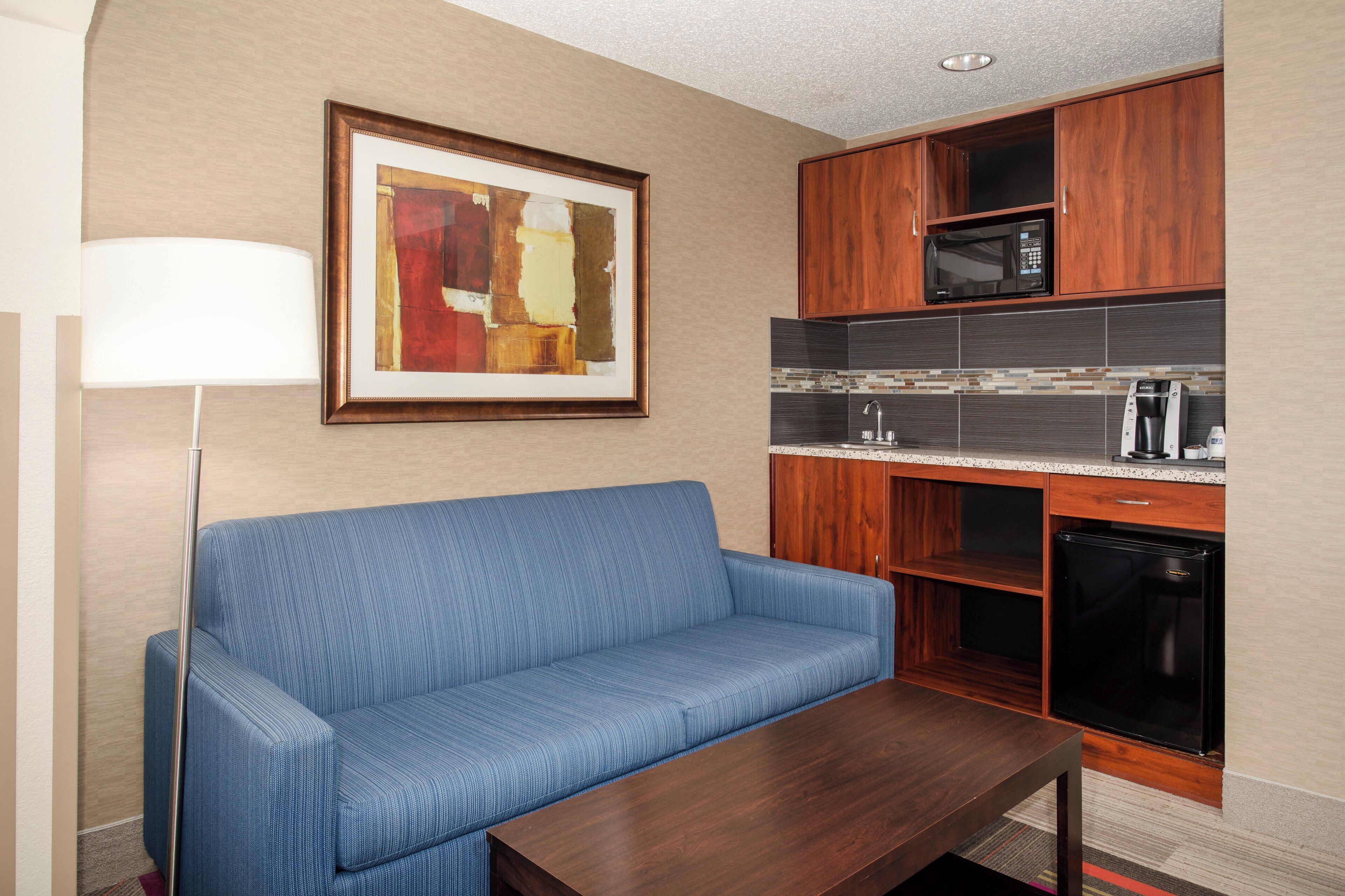 A modern kitchenette with a microwave, coffee maker, and dishwasher.