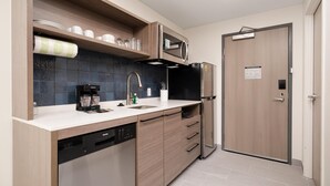 Una cocina moderna con lavavajillas, microondas y una puerta con un letrero.